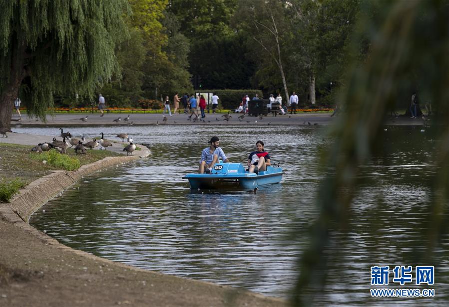 7月31日，人们在英国伦敦摄政公园的湖中踩脚踏船。新华社记者 韩岩 摄