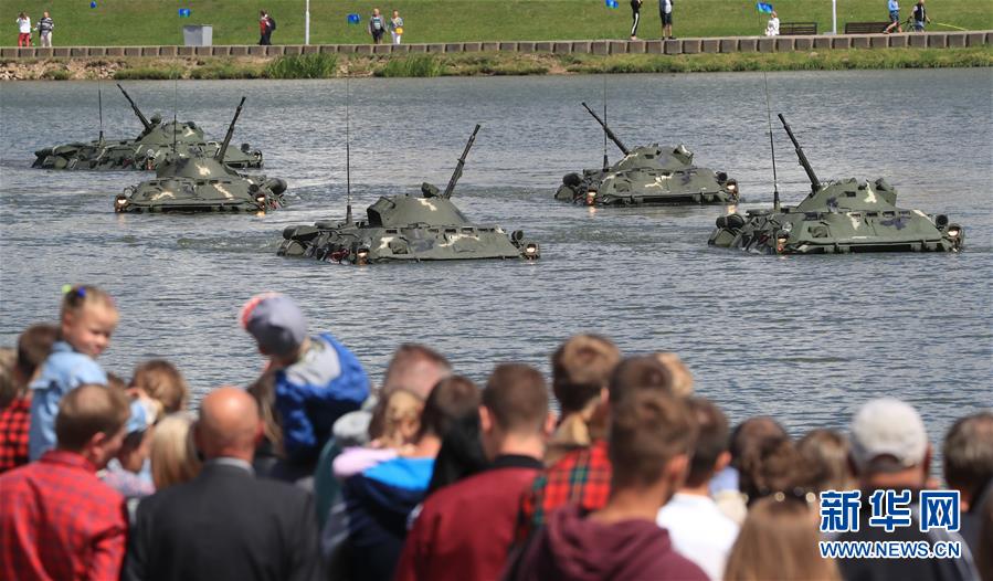 8月1日，在白俄罗斯首都明斯克，人们观看装甲车辆在水上进行的表演。 新华社发（任科夫摄）