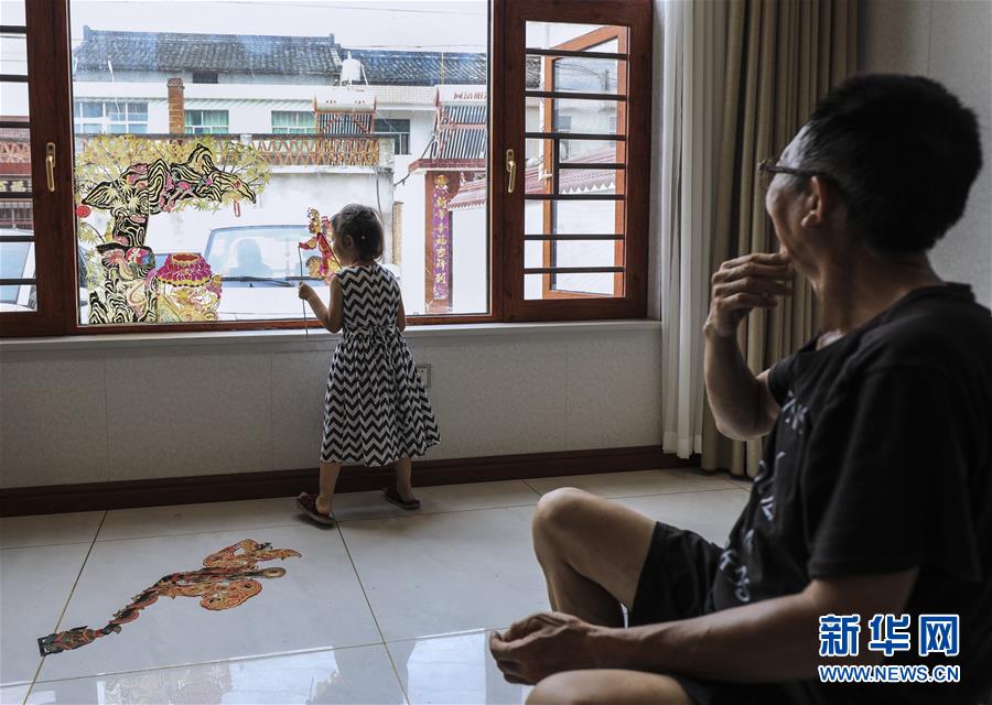 8月1日，皮影艺人蔡善存在家中与小孙女玩皮影。 新华社记者 兰红光 摄