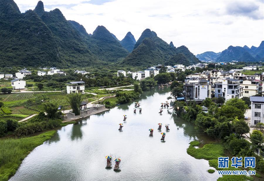 8月2日，在广西桂林市阳朔县，游人乘坐竹筏在遇龙河上游玩（无人机照片）。 新华社发（李斌 摄）