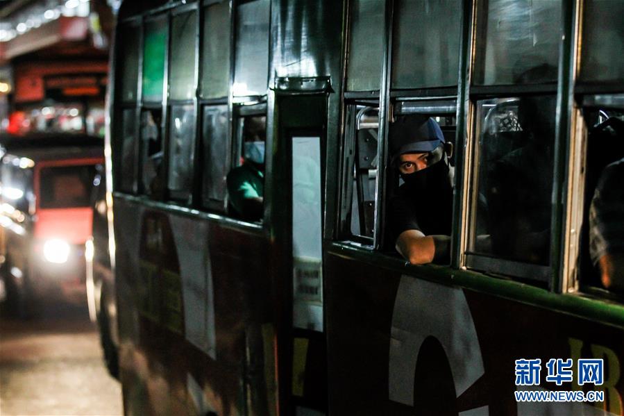8月3日，在菲律宾马尼拉，一名戴口罩的男子看向公交车窗外。 菲律宾政府2日晚间宣布，为了遏制新冠疫情蔓延，该国将从4日起在马尼拉及周边四个省重新收紧防疫隔离措施，为期半个月。上述地区民众外出活动将受到限制，公共交通将再度停运，一些已复工的工商业将部分停工，政府部门将只保留基本人力，其余人员全部在家办公。 新华社发（乌马利 摄）