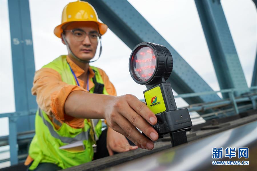 8月6日，防护员陈飞在南京长江大桥作业点安放施工作业防护灯。新华社记者 李博 摄