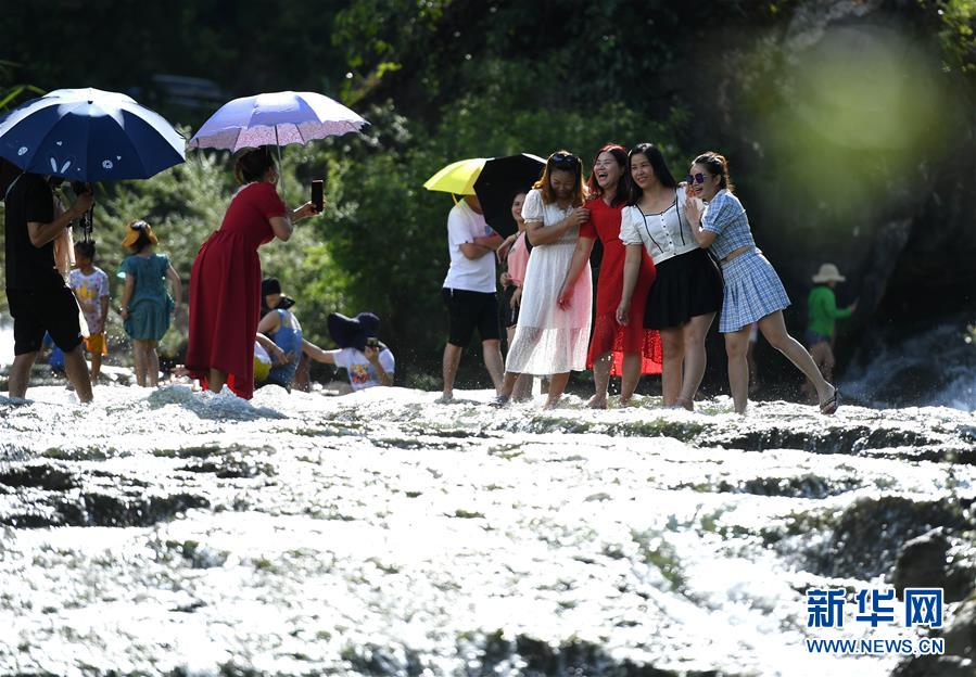 8月6日，游人在广西柳州市鹿寨县中渡镇响水瀑布景区里戏水游玩（无人机照片）。 连日来，广西柳州市持续高温天气，柳州市鹿寨县中渡镇响水瀑布景区成为人们休闲避暑的好去处，人们亲水游玩，享受清凉。 新华社发（黎寒池 摄）