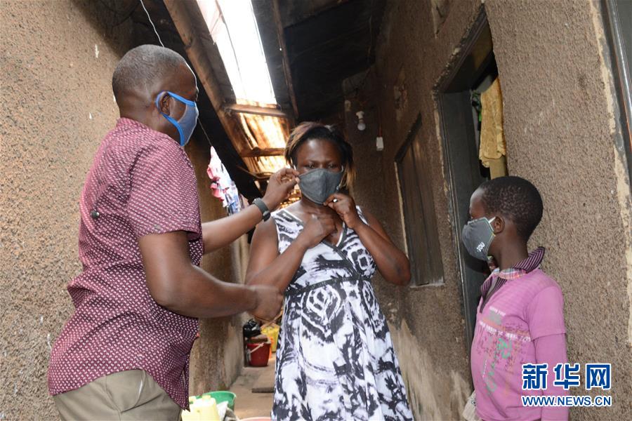 8月7日，在乌干达坎帕拉，地方官员向居民分发口罩。 近日，为控制新冠疫情，乌干达政府在首都坎帕拉免费发放约200万个口罩。 新华社发（尼古拉斯·卡乔巴 摄）