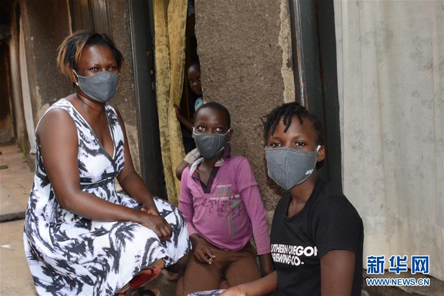 8月7日，在乌干达坎帕拉，居民戴着政府分发的口罩。 近日，为控制新冠疫情，乌干达政府在首都坎帕拉免费发放约200万个口罩。 新华社发（尼古拉斯·卡乔巴 摄）