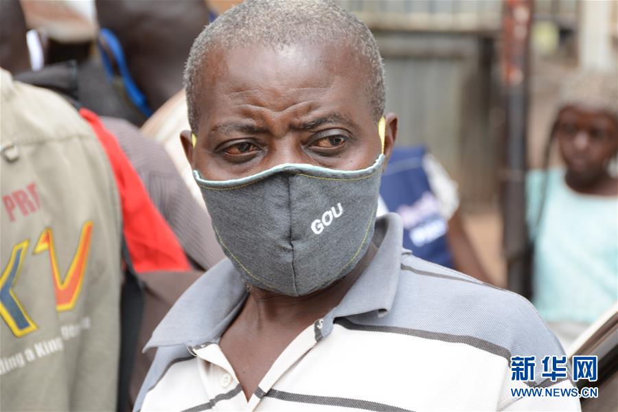 8月7日，在乌干达坎帕拉，一名男子戴着政府分发的口罩。 近日，为控制新冠疫情，乌干达政府在首都坎帕拉免费发放约200万个口罩。 新华社发（尼古拉斯·卡乔巴 摄）