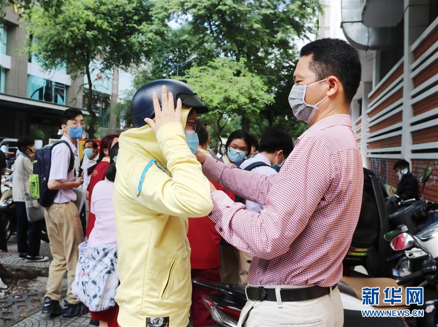 8月9日，在越南南部胡志明市一处考点外，家长迎接结束首场考试的考生。 2020年越南国家高中毕业和大学入学统一考试9日在疫情下拉开帷幕，全国86万余名考生参加。 新华社/越通社