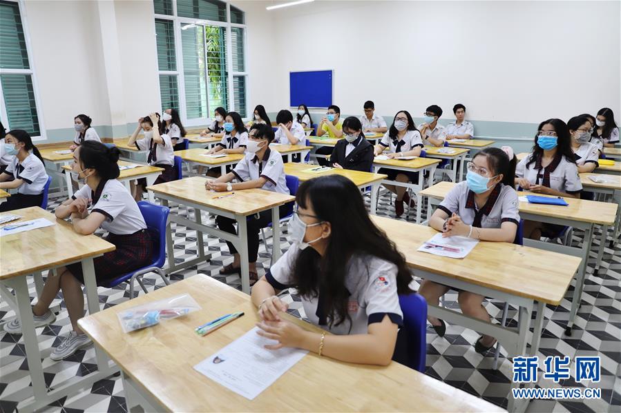 8月9日，在越南南部胡志明市，佩戴口罩的考生们参加考试。 2020年越南国家高中毕业和大学入学统一考试9日在疫情下拉开帷幕，全国86万余名考生参加。 新华社/越通社
