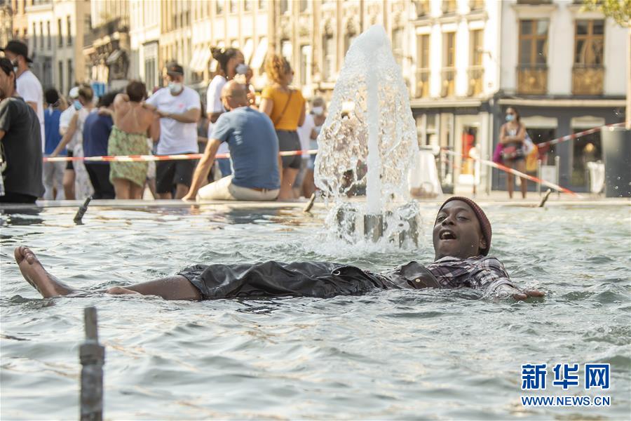 8月9日，一名男子在法国北部城市里尔一处喷泉里消暑。 法国各地近日被热浪席卷，包括巴黎省在内的多个省发布高温红色警报，法国气象局预计高温天气将至少持续到下周中期。 新华社发（塞巴斯蒂安·库尔吉摄）