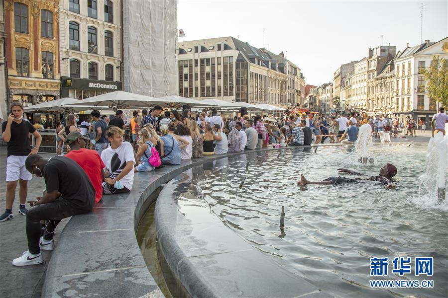 8月9日，人们在法国北部城市里尔一处喷泉旁消暑。 法国各地近日被热浪席卷，包括巴黎省在内的多个省发布高温红色警报，法国气象局预计高温天气将至少持续到下周中期。 新华社发（塞巴斯蒂安·库尔吉摄）