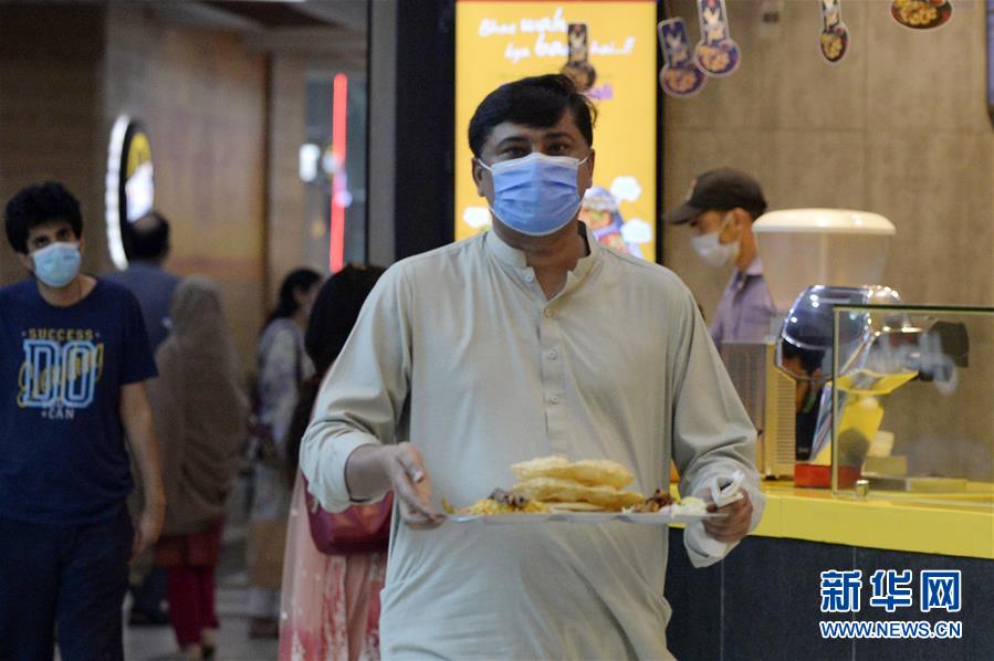8月10日，一名男子在巴基斯坦伊斯兰堡的一家商场用餐。 据当地媒体报道，巴基斯坦政府10日起进一步放宽疫情防控措施，包括允许剧院、电影院、餐厅等场所重新开放营业。 新华社发（艾哈迈德·卡迈勒摄）