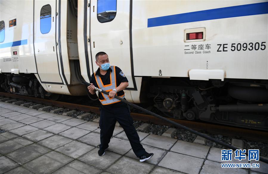 8月12日，长春火车站客运车间上水工常明为刚刚到站的一趟列车上水。 新华社记者 林宏 摄
