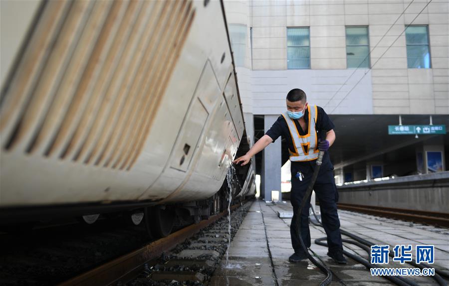 8月12日，长春火车站客运车间上水工龚关在给列车上水。  新华社记者 林宏 摄