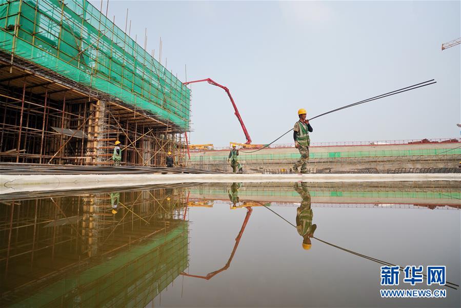 工人在雄安新区容东片区安置房及配套设施项目建设现场搬运建材（8月11日摄）。 记者从河北雄安新区管委会了解到，雄安新区2020年谋划提出百余个重点建设项目，截至7月底，近70个项目已主体开工或配套辅助设施工程开工。 新华社记者 牟宇 摄