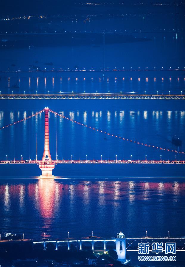 8月14日拍摄的武汉长江大桥、鹦鹉洲长江大桥、杨泗港长江大桥、白沙洲大桥（从前往后）。 夏夜的江城武汉景色迷人，美不胜收。 新华社记者 肖艺九 摄