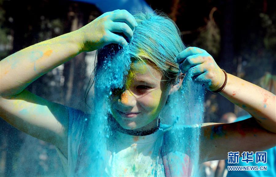 8月16日，一个孩子在拉脱维亚海滨城市尤尔马拉参加色彩节活动。 当天，色彩节活动在拉脱维亚海滨城市尤尔马拉举办，近2000人参加。拉脱维亚近期放宽了针对新冠疫情的防控限制，允许举行不超过3000人参加的户外活动。 新华社发（艾迪斯摄）