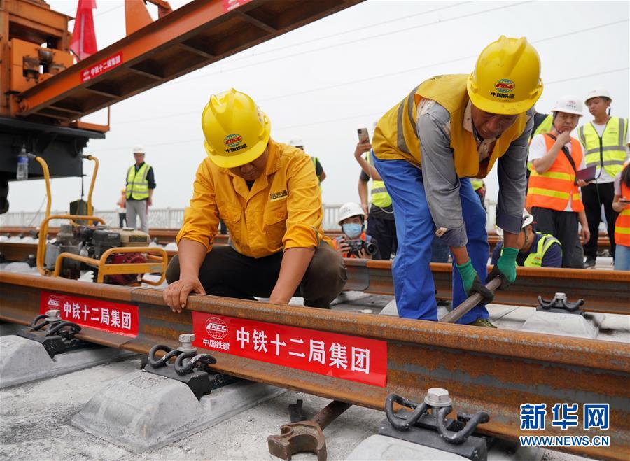 8月17日，中铁十二局工人在进行铺轨作业。 当日，京雄城际铁路最后一组500米长钢轨在河北雄安新区铺设完成，标志着京雄城际铁路全线轨道贯通。 新华社记者 牟宇 摄