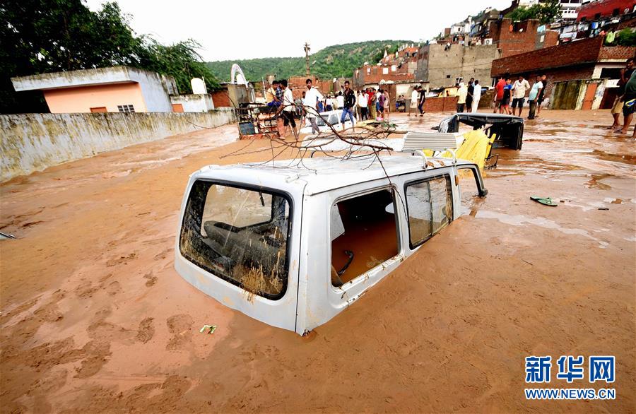 8月14日，在印度拉贾斯坦邦首府斋普尔，一场暴雨过后，雨水冲刷带来的淤泥将街头的车辆埋没。 新华社发