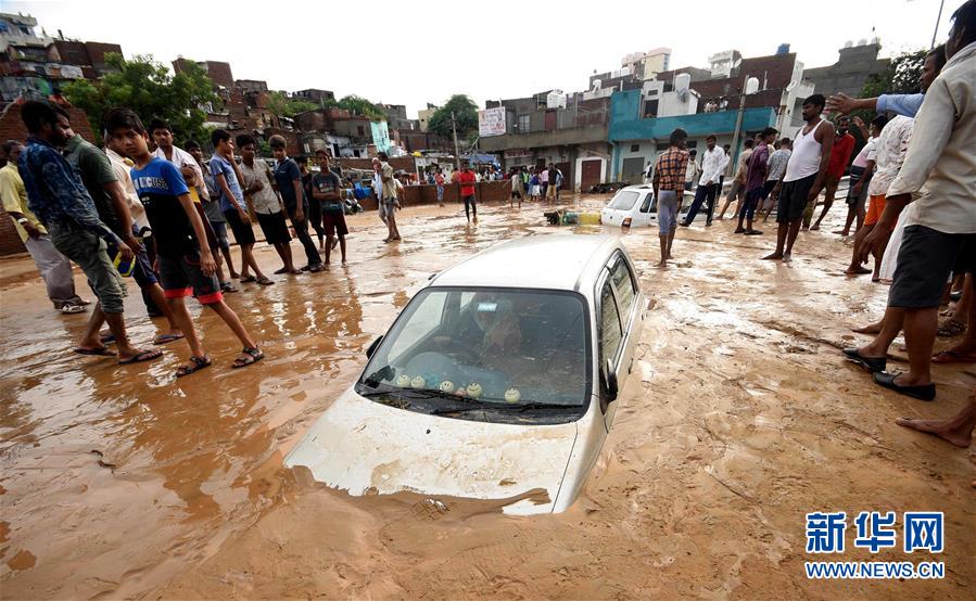 8月14日，在印度拉贾斯坦邦首府斋普尔，一场暴雨过后，雨水冲刷带来的淤泥将街头的车辆埋没。 新华社发