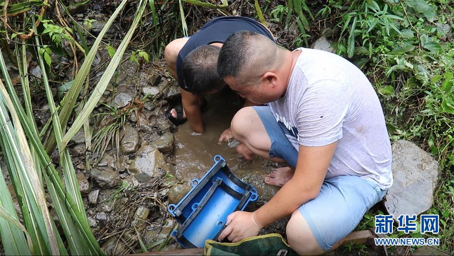 月12日，湖南省张家界市桑植县陈家河镇供水站站长廖涛与王波在管道漏水点安装抢修节。新华社记者 蔡潇潇 摄