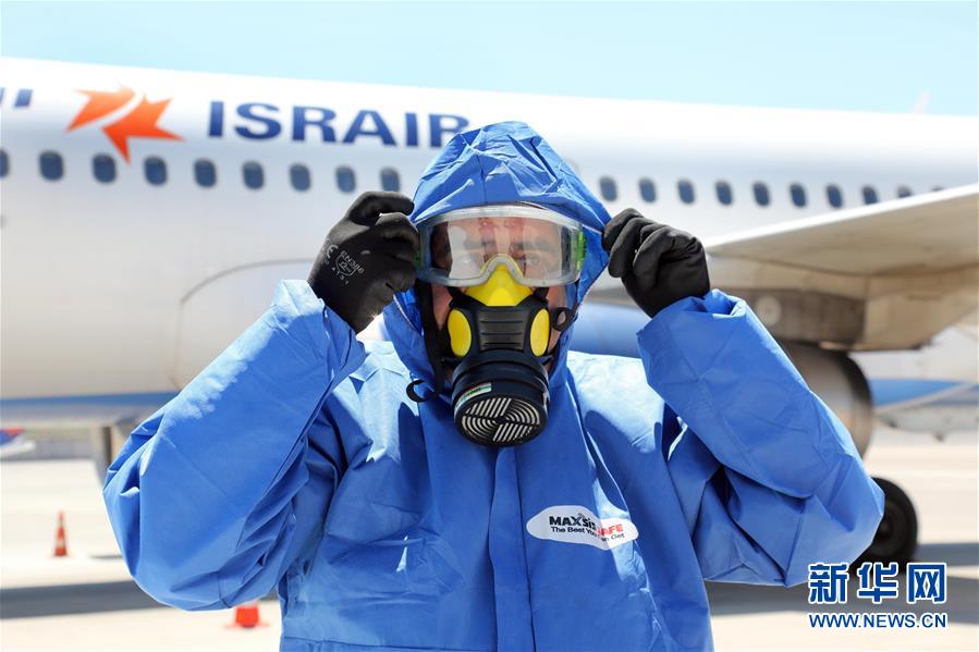 8月17日，一名工作人员在以色列本古里安国际机场的一架空客A320客机前穿戴防护设备。 新华社发（吉德翁摄）