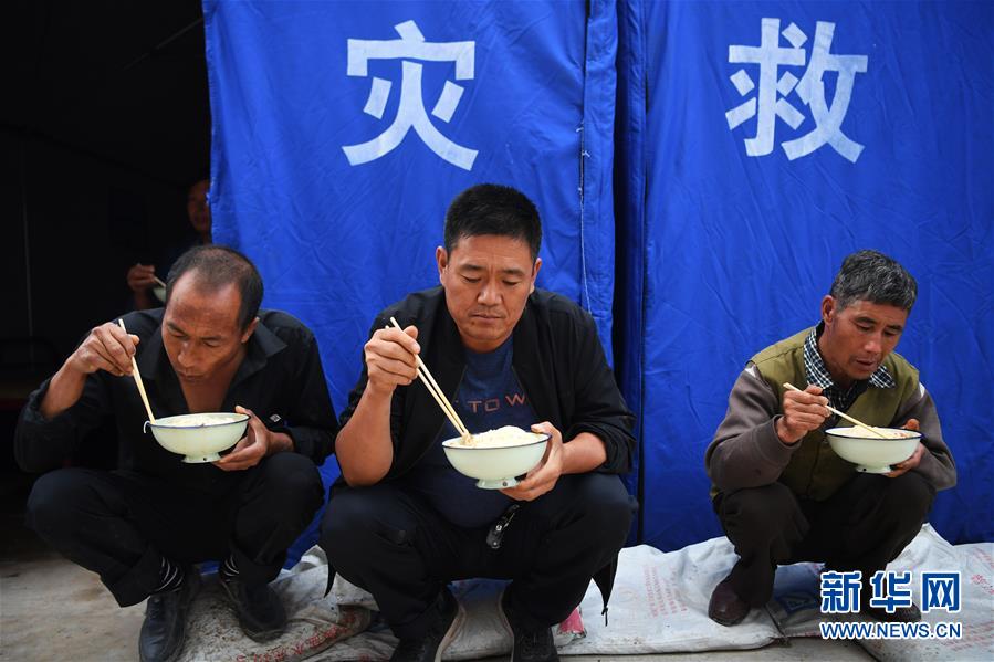 8月18日，在陇南市武都区马街镇泉家湾村临时集中安置点，村民吃上热腾腾的晚饭。 近日，甘肃省陇南市持续遭遇强降雨，多个县区出现滑坡、泥石流等自然灾害。当地政府在学校、企业厂房等安全地带建立临时安置点，转移安置受灾群众，保障受灾群众的基本生活。 新华社记者 陈斌 摄