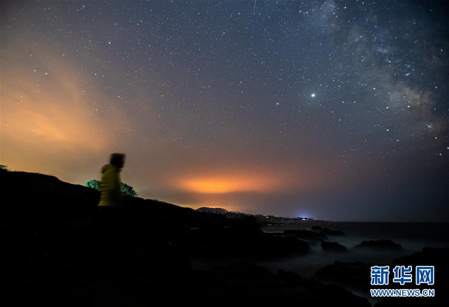 这是8月17日晚在美国加利福尼亚州的半月湾附近拍摄的夜空。 美国加利福尼亚州近日炎热干燥，野火肆虐，入夜后火光映红天空。 新华社发（董旭东摄）