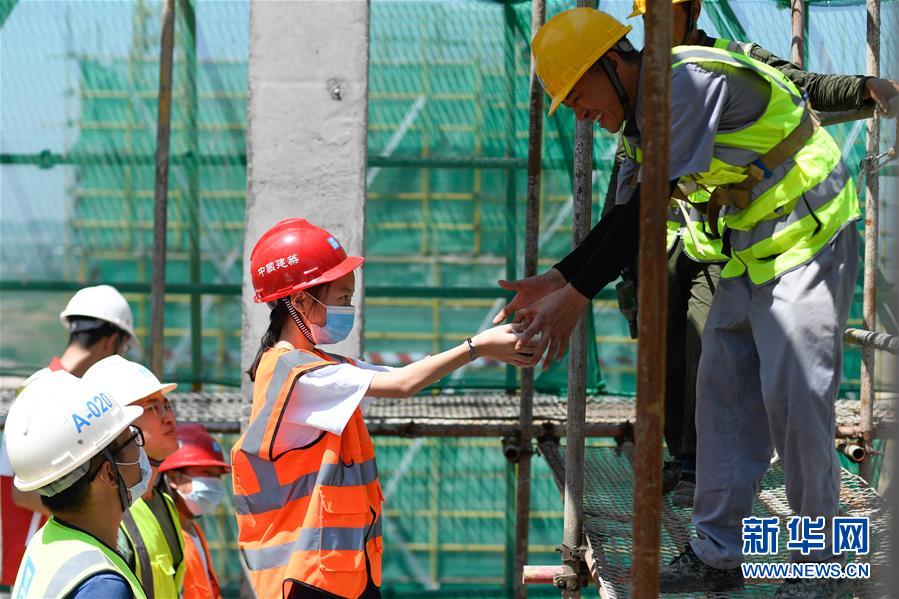 8月19日，“小候鸟”在浙江义乌世茂项目建设工地为工人送上清凉食品。 当日，在中建三局三公司华东分公司浙江义乌世茂项目建设工地，来自安徽、江西、湖北等地的26位外来务工人员子女参加了为他们组织的夏令营公益活动。即将陆续返乡的“小候鸟”们上了一堂安全课程，还参观了父母工作的建设工地。 新华社记者 黄宗治 摄