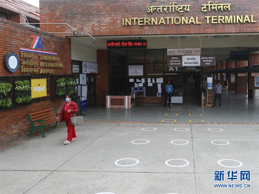 8月22日，一名女子走出尼泊尔加德满都特里布万国际机场的航站楼。 尼泊尔政府21日宣布，将从9月1日开始有限恢复国际航班，允许特定国家和地区的特定人群入境，但暂时不允许游客入境。 新华社记者 周盛平 摄