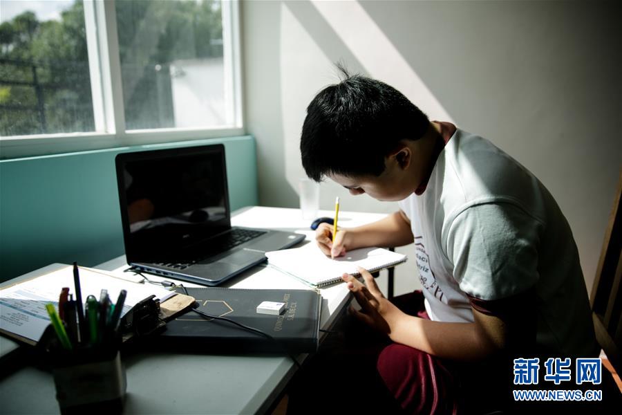 8月24日，在墨西哥首都墨西哥城，16岁的奥斯卡·科尔德罗在电脑前记笔记。 墨西哥学校的2020-2021学年于当日开学，受疫情影响，目前课程基本以在线方式进行。 新华社发（弗兰西斯科·卡涅多 摄）