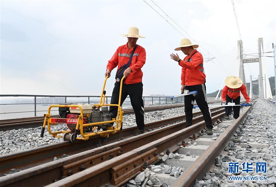 8月24日，中国铁路南昌局集团有限公司福州工务段施工人员在福平铁路乌龙江大桥上进行精调施工作业。 新华社记者林善传摄