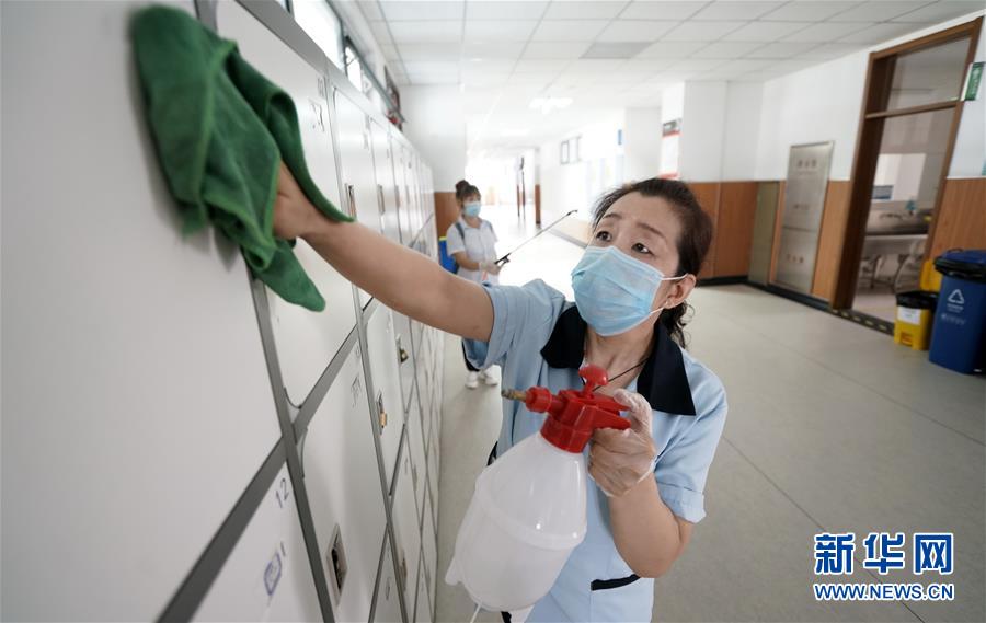 8月26日，北京市第十二中学钱学森学校的保洁人员在清洁教学楼内的设施。新华社记者 李欣 摄