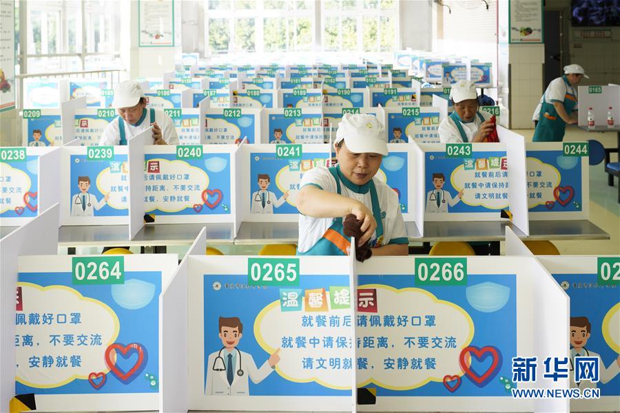 8月26日，在重庆市江北中学食堂，工作人员在打扫餐桌卫生。 近日，位于重庆市北碚区的重庆市江北中学组织人员清洁校园，并对学校食堂、教室、寝室等公共场所进行集中消杀，做好准备迎接新学期的到来。 新华社发（秦廷富 摄）