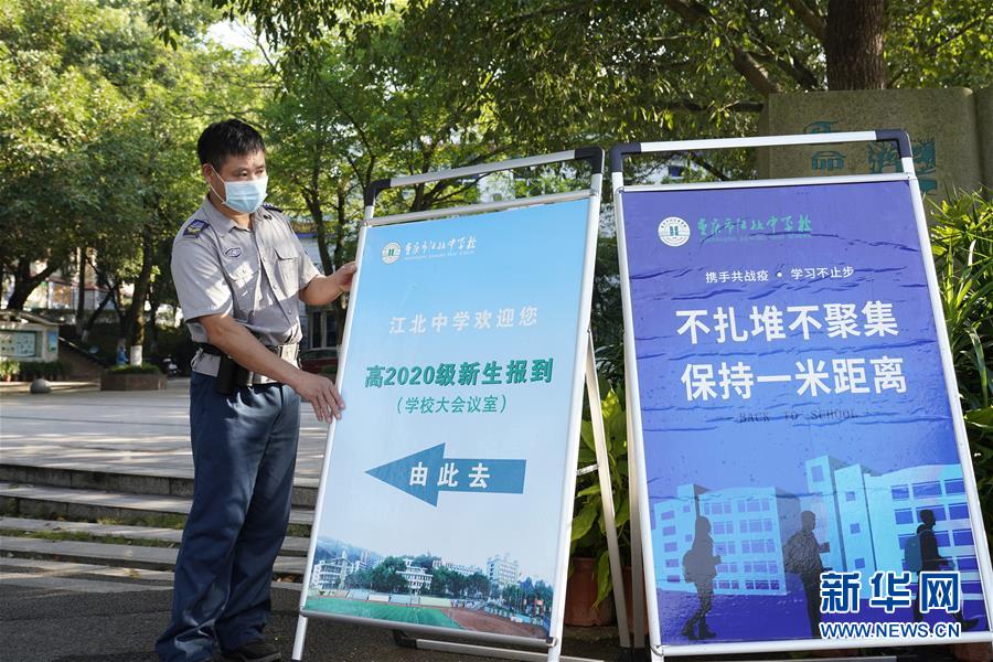 8月26日，在重庆市江北中学，安保人员在摆放指示牌。 新华社发（秦廷富 摄）