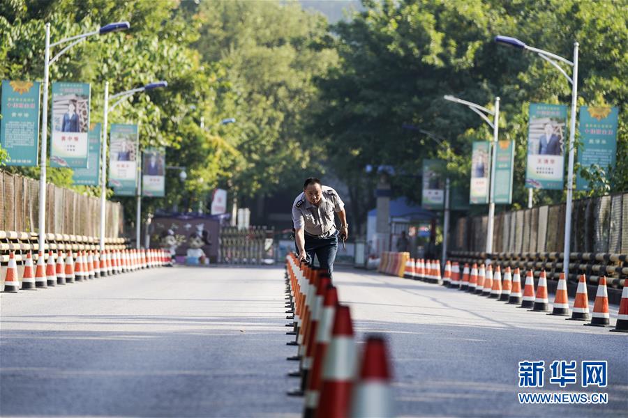 8月26日，在重庆市江北中学，安保人员在大门口摆放隔离桩。 新华社发（秦廷富 摄）
