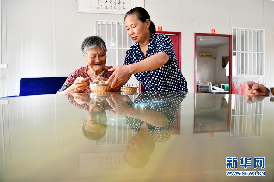 8月30日，傅兴芳在老年服务中心里为老人送上午餐。新华社记者 刘军喜 摄