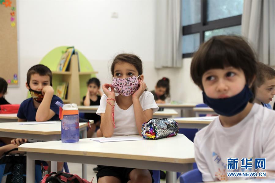 这是9月1日在以色列中部城市特拉维夫一所小学的教室内拍摄的佩戴口罩的学生。 以色列中小学的新学年于9月1日开始，低年级（1至4年级）进行小班教学，中高年级（5至12年级）则主要是远程在线学习。 新华社/基尼图片社