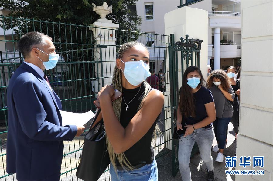 9月1日，在法国南部城市尼斯的一所中学，学生们戴口罩来到学校报到。 法国9月1日迎来新学年第一天，中小学生重返校园。 新华社发（塞尔日·阿乌齐 摄）