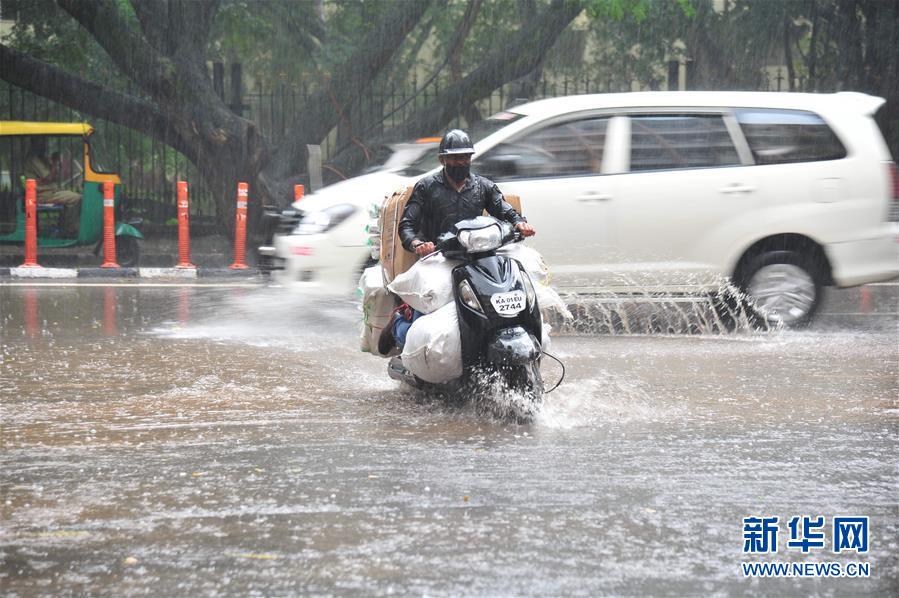 9月2日，印度班加罗尔的行人冒雨出行。 印度每年6月至9月是季风雨季。 新华社发