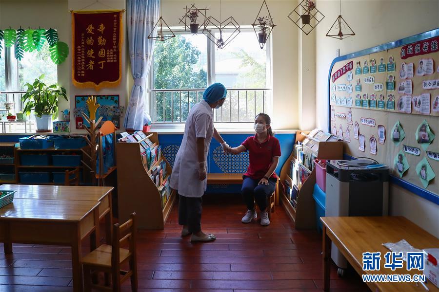 9月3日，在中国儿童中心实验幼儿园，参加模拟演练的校医模拟为发烧的“学生”检查。 近日，北京市各幼儿园为开园做准备，部分幼儿园进行开园的模拟演练。受新冠肺炎疫情影响，今年北京市中小学、幼儿园实行分批、错峰开学。9月8日起，各类型幼儿园大班、中班开园。9月11日各类型幼儿园小班开园后，北京市中小学幼儿园将全部开学。 新华社记者 张玉薇 摄