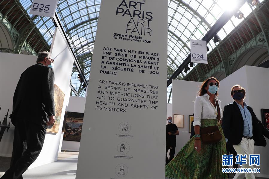 9月9日，人们在法国巴黎大皇宫举行的2020巴黎艺术博览会预展上经过防疫告示牌。 2020巴黎艺术博览会于9月10日至13日在法国巴黎大皇宫举行，来自15个国家和地区的112家画廊参加。受新冠疫情影响，原定于4月初举办的巴黎艺术博览会推迟了半年举行。现场配备免洗消毒洗手液，所有人员必须佩戴口罩并保持安全距离。 新华社记者 高静 摄