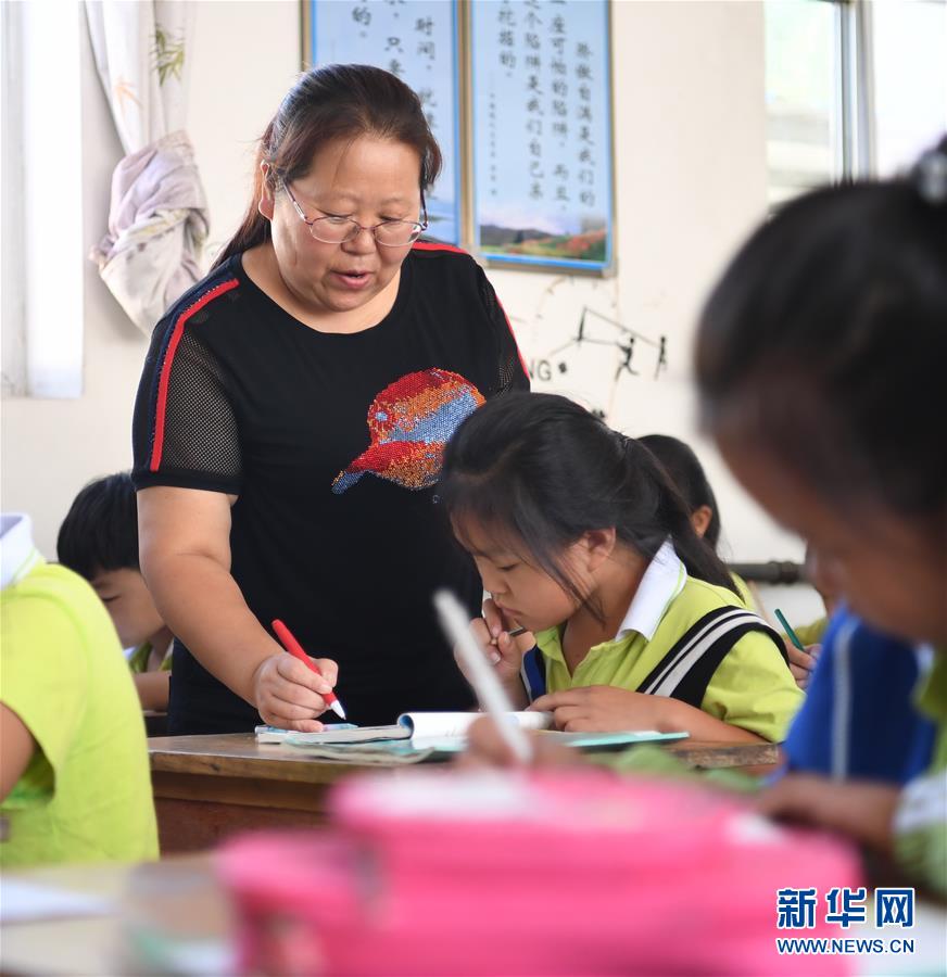 9月10日，郭自然在课堂上为孩子们辅导功课。 新华社记者 朱旭东 摄