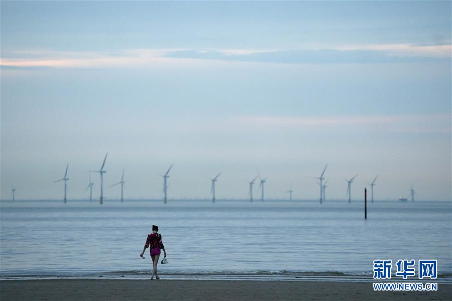 9月14日，一名女子在英国克罗斯比海边休闲。 根据英国首相约翰逊宣布的疫情防控新举措，自9月14日起，除少数情况外，日常社交场合中的聚集人数不得超过6人，室内室外均适用，违者可能面临罚款等处罚。不过，学校和工作场合等并不受影响。 新华社发（乔恩·休珀摄）