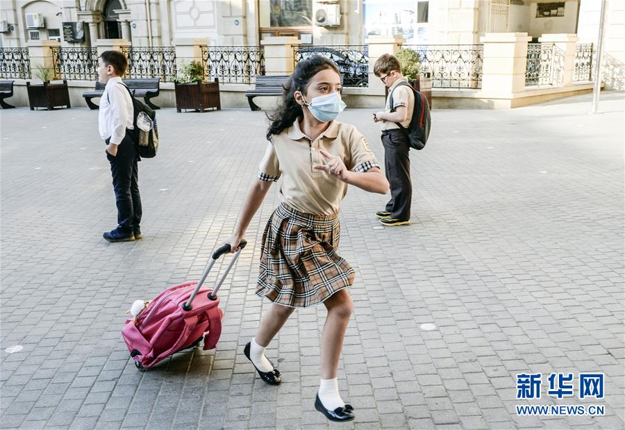 9月15日，在阿塞拜疆首都巴库，一名小学生准备进入学校。 当日，阿塞拜疆2020-2021学年开学。 新华社发（巴巴耶夫 摄）