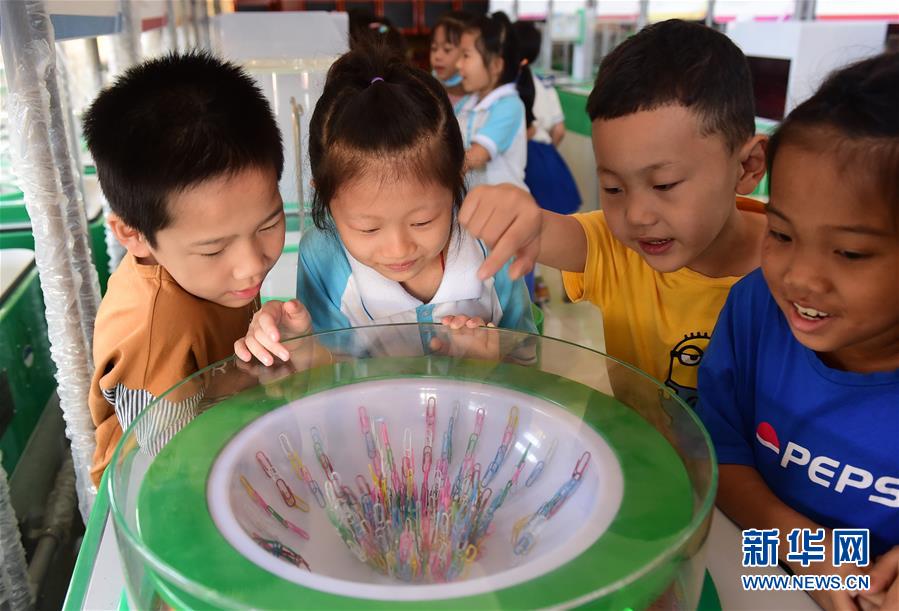 9月18日，沧州市新华区路华小学的学生在“流动科技馆”里体验“跳舞回形针”。 今年全国科普日活动将于9月19日至25日在全国各地集中开展。9月18日，以“体验科学”为主题的中国流动科技馆全国巡展来到河北省沧州市新华区，公众可在互动体验的过程中近距离感知科技的魅力，接受科普教育。 新华社记者 王民 摄