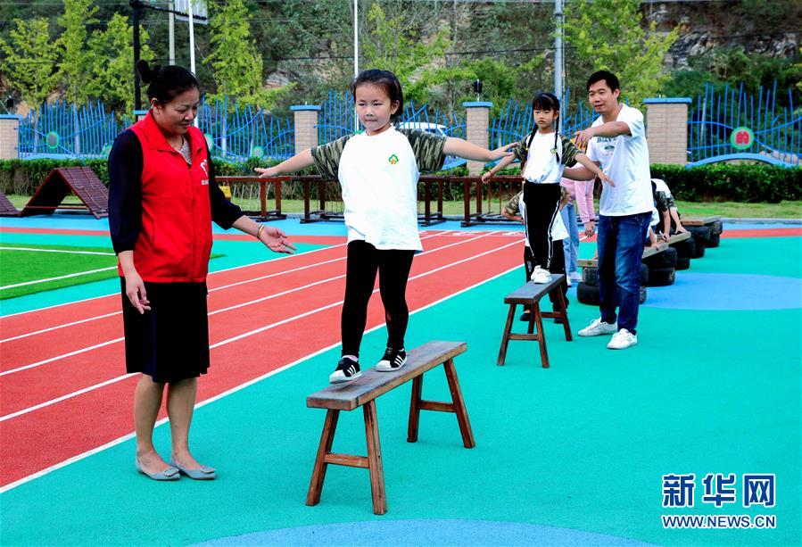 9月24日，孩子们在老师的带领下进行走平衡木练习。 当日，浙江省湖州市长兴县煤山镇槐坎中心幼儿园开展校园金秋运动日活动。孩子们在老师和家长志愿者的带领下，进行走、跑、跳、平衡等户外拓展运动技能的练习，让孩子们在快乐中锻炼身体。 新华社记者 徐昱 摄