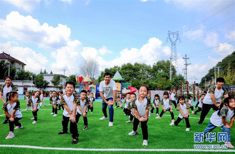 9月24日，孩子们在老师的带领下进行身体拉伸运动。 当日，浙江省湖州市长兴县煤山镇槐坎中心幼儿园开展校园金秋运动日活动。孩子们在老师和家长志愿者的带领下，进行走、跑、跳、平衡等户外拓展运动技能的练习，让孩子们在快乐中锻炼身体。 新华社记者 徐昱 摄