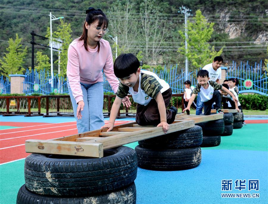 9月24日，孩子们在老师的带领下进行跨越障碍物运动。 当日，浙江省湖州市长兴县煤山镇槐坎中心幼儿园开展校园金秋运动日活动。孩子们在老师和家长志愿者的带领下，进行走、跑、跳、平衡等户外拓展运动技能的练习，让孩子们在快乐中锻炼身体。 新华社记者 徐昱 摄