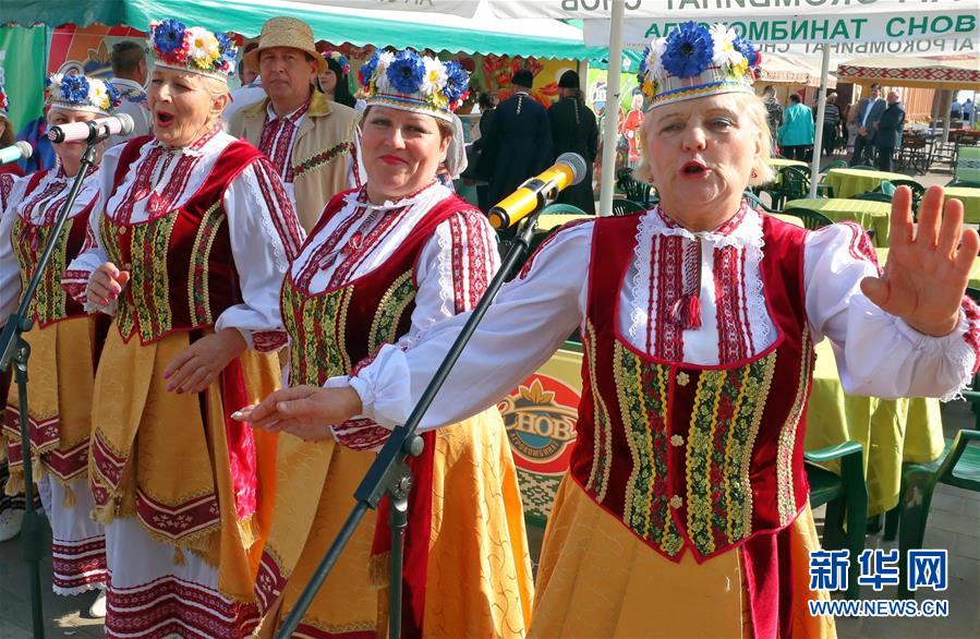 9月26日，在白俄罗斯首都明斯克郊区，人们身着民族服饰在农业展销节上演唱歌曲。 随着当地秋收的基本结束，白俄罗斯各地相继举办农业展销节等活动，欢庆秋收。 新华社发（任科夫摄）