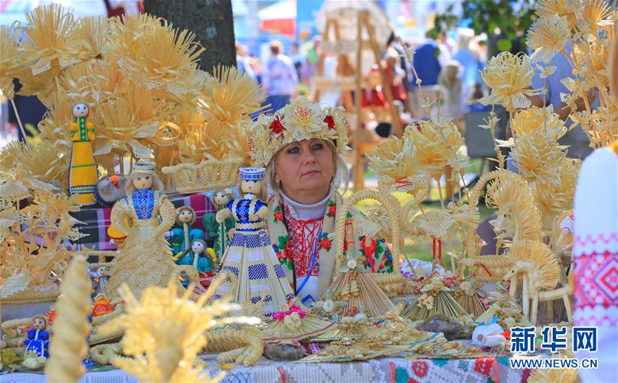9月26日，在白俄罗斯首都明斯克郊区，一名女子展售麦秆制作的各类手工艺品。 随着当地秋收的基本结束，白俄罗斯各地相继举办农业展销节等活动，欢庆秋收。 新华社发（任科夫摄）